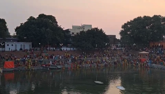 Traditional Chhath Puja ceremony with devotees offering prayers to setting sun at river bank