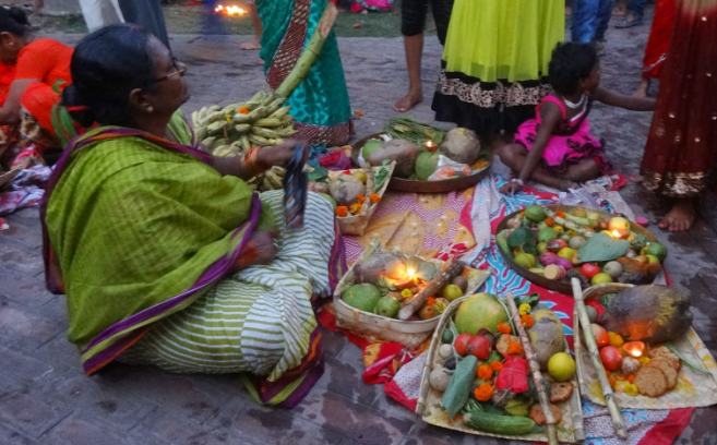 Devotees making offerings of fruits and traditional sweets during Chhath festival